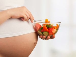 healthy nutrition and pregnancy. pregnant woman's belly and vegetable salad